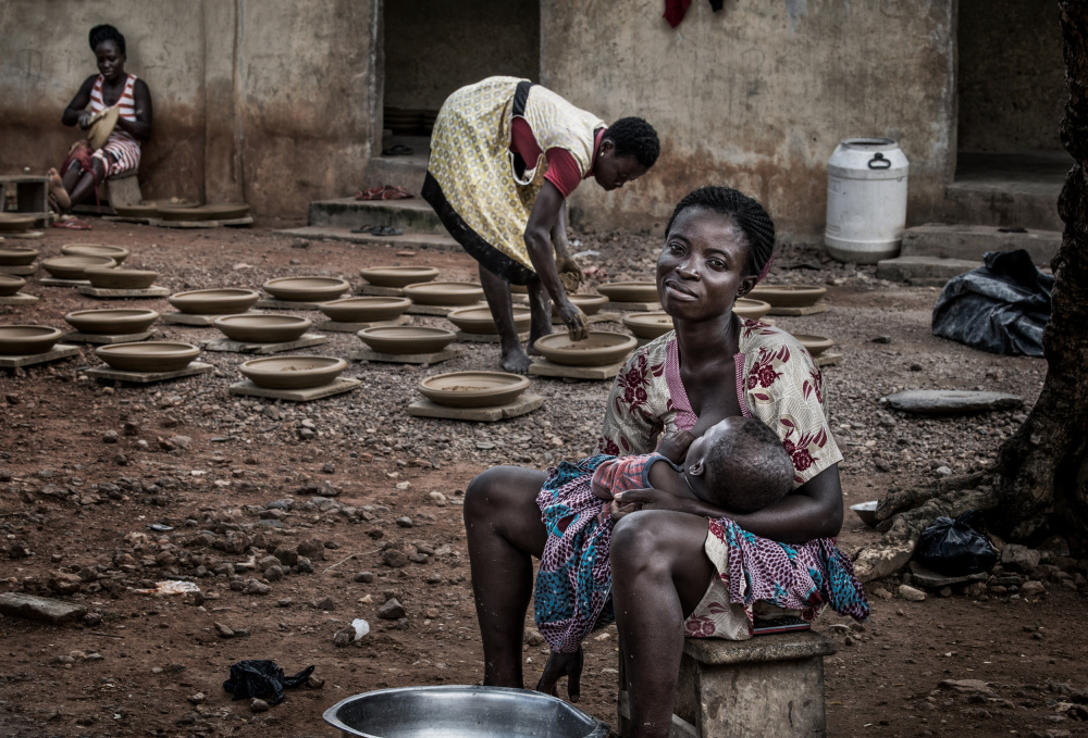 A break in the making of pottery to breastfeed her child - Ghana od Joxe Inazio Kuesta Garmendia