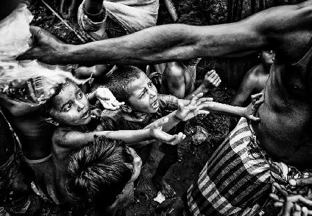 Rohingya refugee children demanding their share of the distribution of snacks.