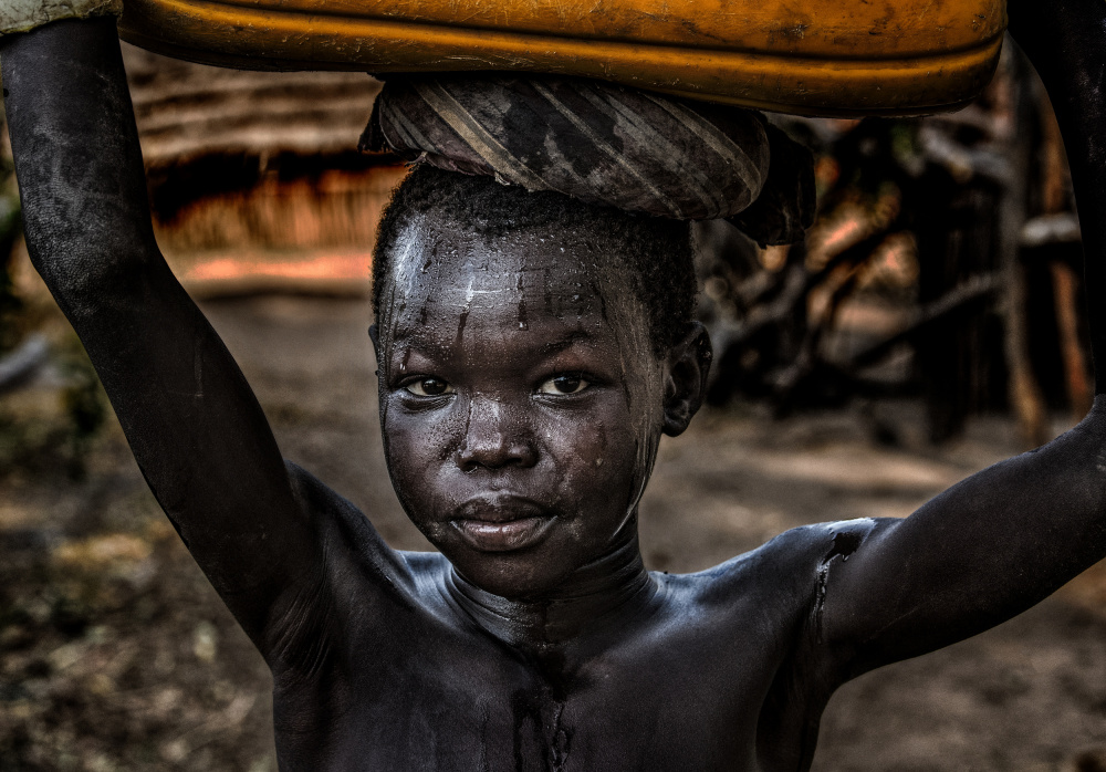 South sudanian child carrying a water containera od Joxe Inazio Kuesta Garmendia