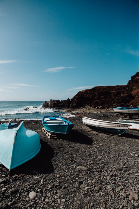 Blaue Boote auf schwarzem Vulkansstrand auf Lanzarote od Laura Nenz