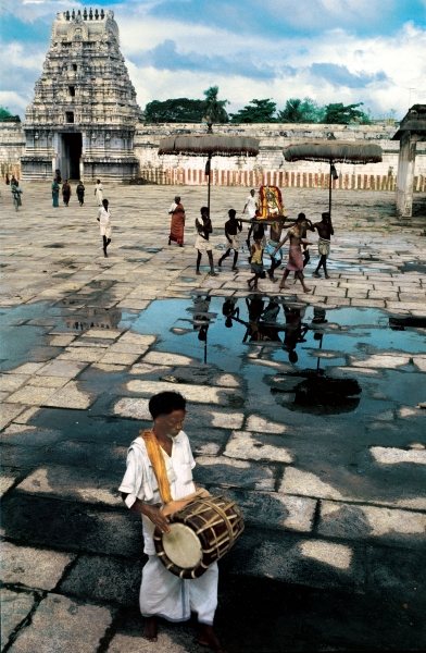 Drummer and devotees reflected in pool of water (photo)  od 