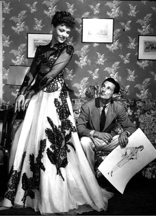 fashion designer Oleg Cassini showing his drawings to Gene Tierney to show her the clothes for film  od 