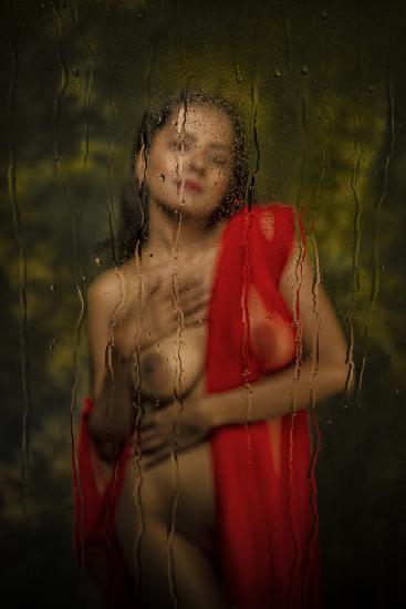 A BEAUTIFUL LADY BEHIND WET GLASS