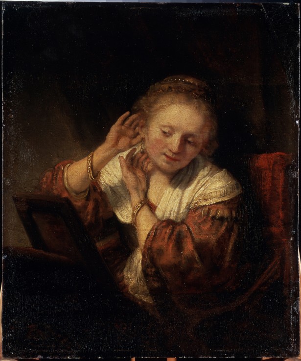 Young Woman trying on Earrings od Rembrandt van Rijn