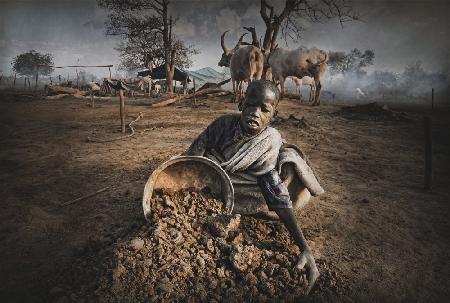 Boy from Mundari collects cow dung